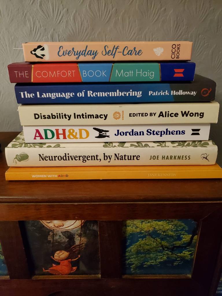 Pile of books about self-care, neurodivergency and disability